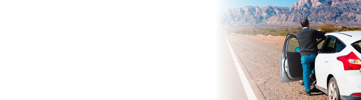 Hombre en carretera revisando su auto y esperando a que llegue la atención de su Seguro Básico Estandarizado Banorte.