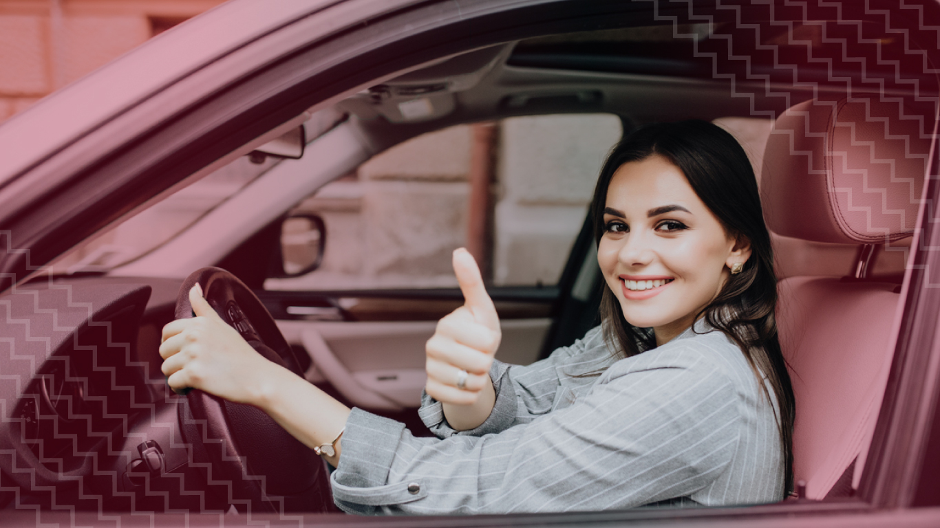 Mujer feliz y confiada dentro de un carro que cuenta con seguro obligatorio para auto.
