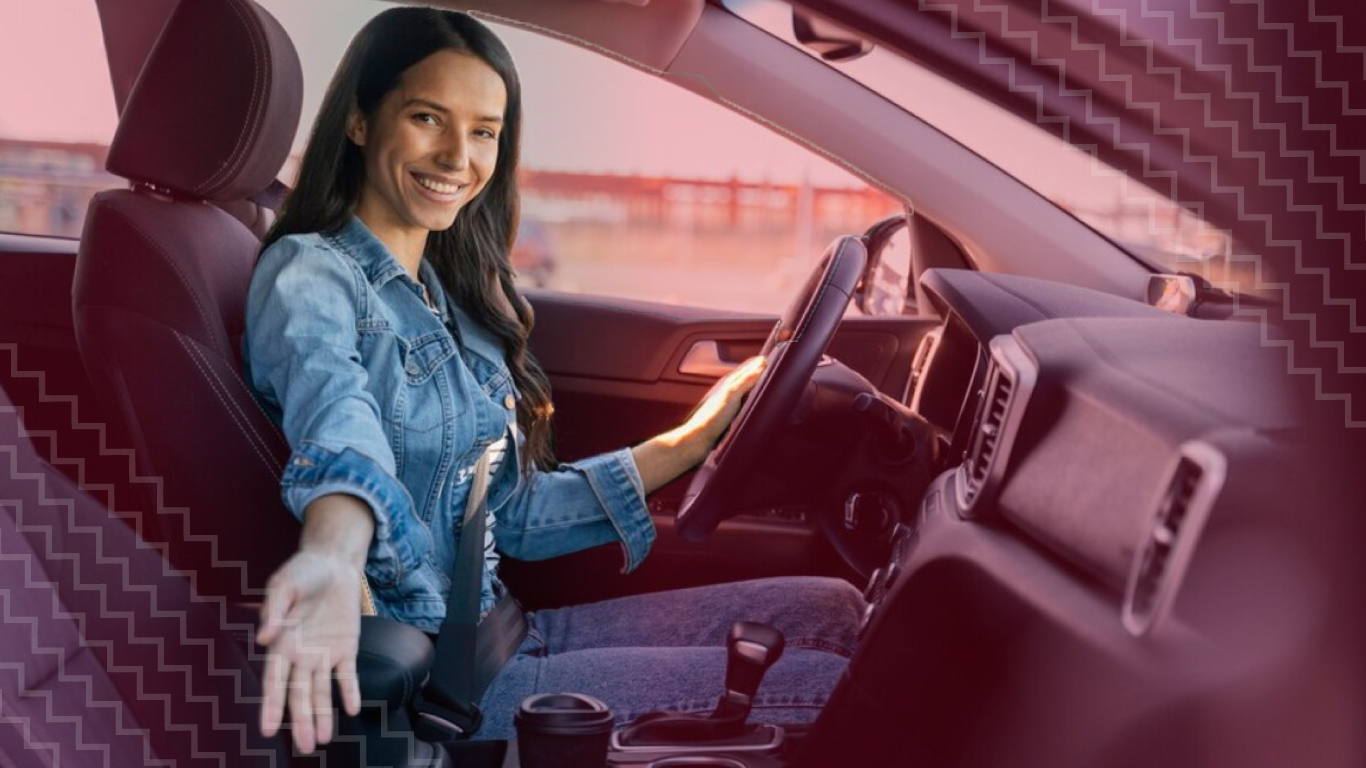 Mujer joven confiada dentro de su vehículo al saber qué es el seguro obligatorio para autos y cuán fácil es contratarlo.